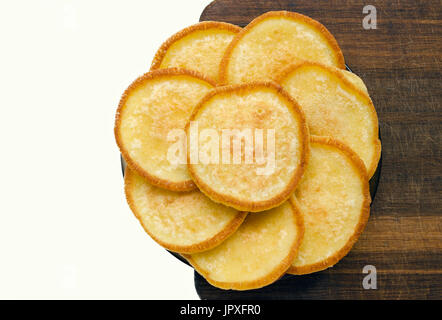 Goldene Pfannkuchen in Form einer Blume auf einem Holzbrett ohne Dekorationen gefüttert. Stockfoto