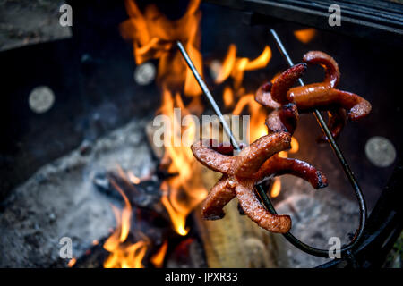 Braten von Würstchen über dem Lagerfeuer Stockfoto