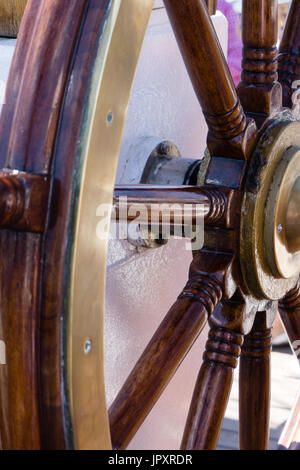 Hintergrund mit einer hölzernen Ruder-Nahaufnahme zu reisen. Schiff-Rad auf der alten Segelschiff - nautische Ausrüstung. Stockfoto