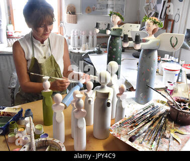 Holz-Designer, die mit Martina Abicht-Lehmann malt französische Acrylfarben Holz Engel, die sie und ihr Ehemann, Pfeifenmachers Peter Lehmann, seit 1989 in ihrem Atelier in den Lehmann-Werkstätten in Hausdorf, in der Nähe von Colditz, Deutschland, 28. Juni 2017 erstellen. Für das Paar ist es derzeit Hochsaison für die Herstellung von verschiedenen Engelfiguren die in Größen zwischen 8 cm und 1,2 Meter sind und die in Zusammenarbeit mit einem Turner und der Dorfschmied gemacht und dann einzeln von Hand bemalt. Mehrere Hundrend der genannten Engel haben bereits versendet worden, aus der Werkstatt Stockfoto