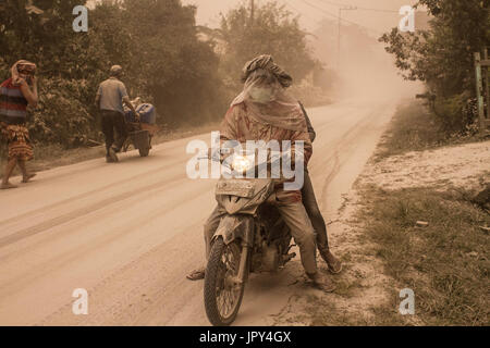 Karo, Nord-Sumatra, Indonesien. 3. August 2017. Anwohner bedeckt in vulkanischen dicker Staub auf ihren Motorrädern, wenn der Ausbruch des Sinabung pyroklastische Ströme in die Luft, in Karo veröffentlicht. Der Vulkan zerstört Vulkanasche so hoch wie 4,2 Kilometer (2,2 Meilen), eines seiner größten Eruptionen. In den letzten Monaten hohe Aktivität. Bildnachweis: Ivan Damanik/ZUMA Draht/Alamy Live-Nachrichten Stockfoto