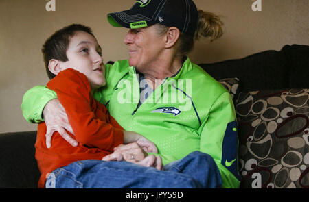 Davenport, Iowa, USA. 12. Januar 2017. Tina McDermott hält Sohn, Ryan, 10, zu Hause in Davenport auf Donnerstag, 12. Januar 2017 McDermott. McDermott war als Kleinkind mit Dravet-Syndrom, einer schweren Form von Epilepsie diagnostiziert und hat derzeit zwischen 10 und 20 Anfälle pro Tag. Eine Cannabis-Öl-Studie durch die Universität von Iowa funktionierte nicht für McDermott, aber er wird in Kürze eine Studie durch die Mayo-Klinik namens Fenfluramin Bewertung bei seltenen Epilepsie beginnen. Bildnachweis: Andy Abeyta/Quad-Stadt-Zeiten / ZUMA Draht/Alamy Live News Stockfoto