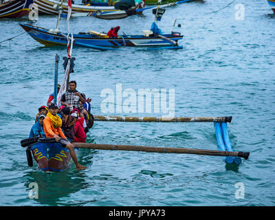 Kuta, Bali, Indonesien. 3. August 2017. Ein Ausleger bringt eine Besatzung von Fischern auf einem Trawler in Ufer am Jimbrana Strand in Kuta zu arbeiten. Der Strand liegt in der Nähe des Flughafens und eine kurze Autofahrt von den anderen Stränden im Südosten Bali. Jimbrana war ursprünglich ein Fischerdorf mit einem geschäftigen Markt. Vor etwa 25 Jahren Entwickler begann mit dem Bau von Restaurants und Hotels entlang der Strand und Land Preise steigen. Der neue Schwerpunkt auf Tourismus verändert sich die Natur der Gegend, aber die Fischer sind noch damit beschäftigt, in den sehr frühen Morgenstunden. Bildnachweis: Jack Kurtz/ZUMA Draht/Alamy Live-Nachrichten Stockfoto