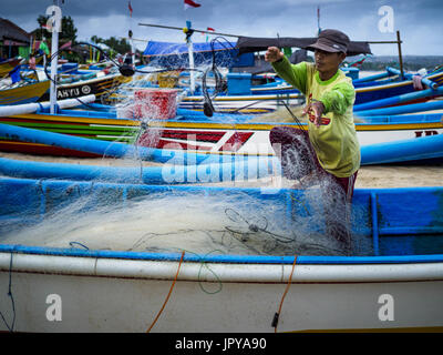 Kuta, Bali, Indonesien. 3. August 2017. Ein Mann verstaut seine Netze auf seine Ausleger-Kanu am Jimbrana Strand in Kuta. Der Strand liegt in der Nähe des Flughafens und eine kurze Autofahrt von den anderen Stränden im Südosten Bali. Jimbrana war ursprünglich ein Fischerdorf mit einem geschäftigen Markt. Vor etwa 25 Jahren Entwickler begann mit dem Bau von Restaurants und Hotels entlang der Strand und Land Preise steigen. Der neue Schwerpunkt auf Tourismus verändert sich die Natur der Gegend, aber die Fischer sind noch damit beschäftigt, in den sehr frühen Morgenstunden. Bildnachweis: Jack Kurtz/ZUMA Draht/Alamy Live-Nachrichten Stockfoto