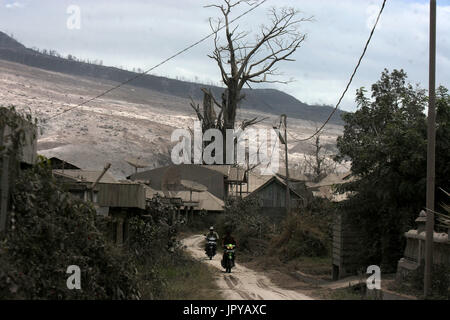 Nord-Sumatra, Indonesien. 3. August 2017. Menschen fahren Motorräder in der Nähe von Mount Sinabung in Karo, Nord-Sumatra, Indonesien, am 3. August 2017. Mount Sinabung Vulkan in der Provinz Nord-Sumatra der westlichen Indonesien brach am Mittwoch, spuckt eine Spalte der Asche von bis zu 4,2 km in den Himmel, national Disaster Management Agency berichtet. Bildnachweis: YT Haryono/Xinhua/Alamy Live-Nachrichten Stockfoto