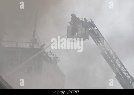 Tokio, Japan. 3. August 2017. Ein Feuerwehrmann versucht, ein Feuer unter Kontrolle außerhalb der Tsukiji-Fischmarkt am 3. August 2017, in Tokio, Japan zu bringen. Das Feuer begann am Nachmittag des Donnerstag 3. wenn der Bereich der kleinen Straßen und Sushi Stände außerhalb des Marktes mit ausländischen Touristen beschäftigt war. Bildnachweis: Rodrigo Reyes Marin/AFLO/Alamy Live-Nachrichten Stockfoto