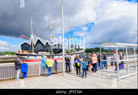 Glasgow, Schottland. 3. August 2017. Großbritannien Wetter. Passagiere warten an den Ufern des Flusses Clyde für die Govan Fähre zu nehmen sie über das Riverside Museum und Großsegler, lebhafteste, an einem sonnigen Tag mit teils sonnig und häufige schwere Duschen Credit: Skully/Alamy Live News Stockfoto