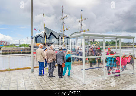 Glasgow, Schottland. 3. August 2017. Großbritannien Wetter. Passagiere warten an den Ufern des Flusses Clyde für die Govan Fähre zu nehmen sie über das Riverside Museum und Großsegler, lebhafteste, an einem sonnigen Tag mit teils sonnig und häufige schwere Duschen Credit: Skully/Alamy Live News Stockfoto