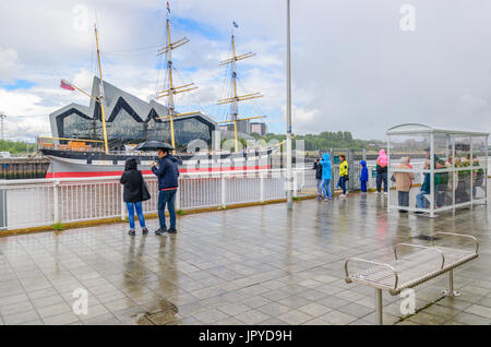 Glasgow, Schottland. 3. August 2017. Großbritannien Wetter. Passagiere warten an den Ufern des Flusses Clyde für die Govan Fähre zu nehmen sie über das Riverside Museum und Großsegler, lebhafteste, an einem sonnigen Tag mit teils sonnig und häufige schwere Duschen Credit: Skully/Alamy Live News Stockfoto