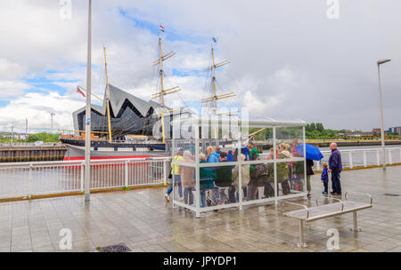 Glasgow, Schottland. 3. August 2017. Großbritannien Wetter. Passagiere warten an den Ufern des Flusses Clyde für die Govan Fähre zu nehmen sie über das Riverside Museum und Großsegler, lebhafteste, an einem sonnigen Tag mit teils sonnig und häufige schwere Duschen Credit: Skully/Alamy Live News Stockfoto
