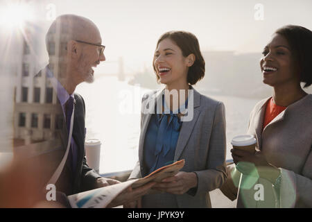 Silhouette Geschäftsleute lachen, Kaffee trinken und Zeitung auf sonnigen städtische Brücke Stockfoto