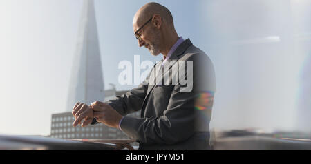 Geschäftsmann Überprüfung Smartwatch im Freien, London, UK Stockfoto