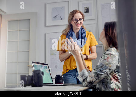 Weibliche Fotografen sprechen, treffen im Büro Stockfoto