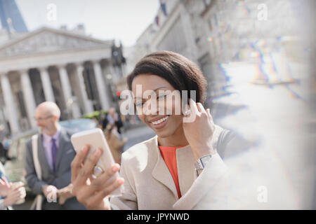 Lächelnde Geschäftsfrau nehmen Selfie mit Kamera-Handy, London, UK Stockfoto