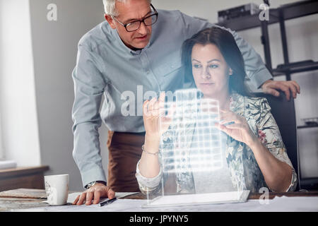 Architektin Durchführung Telekinese, futuristisch leuchtende Plastikmodell schweben Stockfoto