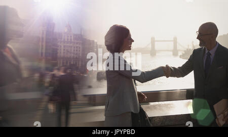 Silhouette Geschäft Leute Handshaking auf sonnigen Brücke über die Themse, London, UK Stockfoto