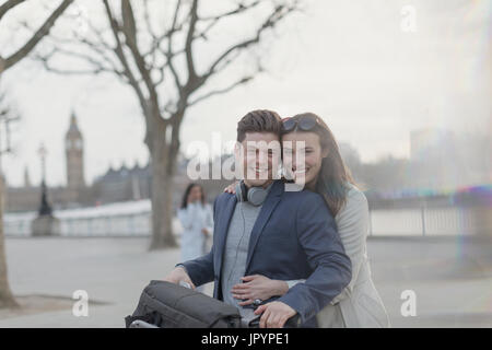 Porträt, Lächeln, umarmen paar Touristen mit dem Fahrrad im städtischen Park, London, UK Stockfoto