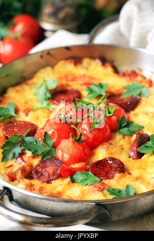 Spanisches Omelett - Tortilla de Patas mit Chorizo und Cherry-Tomaten auf einem Weinstock Stockfoto