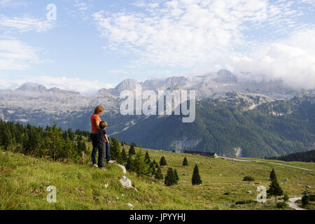 Mutter und Sohn stehen auf den Berg und genießen den Blick über die Bergwelt, er Hochland von Montasio, Julische Alpen, Friaul Julisch Venetien, Italien. Stockfoto