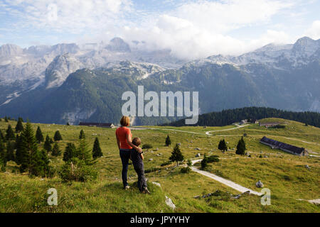 Mutter und Sohn stehen auf den Berg und genießen den Blick über die Bergwelt, er Hochland von Montasio, Julische Alpen, Friaul Julisch Venetien, Italien. Stockfoto