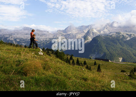 Mutter und Sohn stehen auf den Berg und genießen den Blick über die Bergwelt, er Hochland von Montasio, Julische Alpen, Friaul Julisch Venetien, Italien. Stockfoto