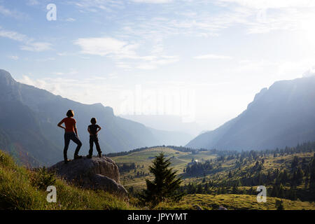 Mutter und Sohn stehen auf den Berg und genießen den Blick über die Bergwelt, er Hochland von Montasio, Julische Alpen, Friaul Julisch Venetien, Italien. Stockfoto