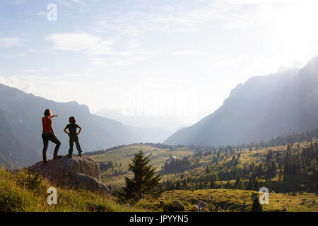 Mutter und Sohn stehen auf den Berg und genießen den Blick über die Bergwelt, er Hochland von Montasio, Julische Alpen, Friaul Julisch Venetien, Italien. Stockfoto