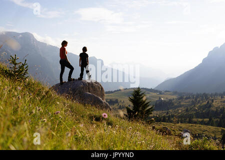 Mutter und Sohn stehen auf den Berg und genießen den Blick über die Bergwelt, er Hochland von Montasio, Julische Alpen, Friaul Julisch Venetien, Italien. Stockfoto