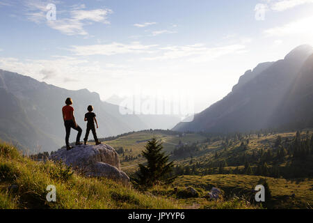 Mutter und Sohn stehen auf den Berg und genießen den Blick über die Bergwelt, er Hochland von Montasio, Julische Alpen, Friaul Julisch Venetien, Italien. Stockfoto