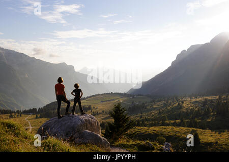 Mutter und Sohn stehen auf den Berg und genießen den Blick über die Bergwelt, er Hochland von Montasio, Julische Alpen, Friaul Julisch Venetien, Italien. Stockfoto