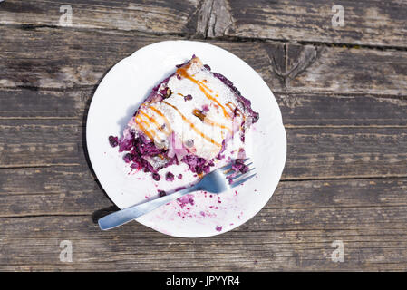 Blueberry Pie Strudel schließen Schuss auf weißen Teller auf alten Holztisch, Torte, die teilweise gegessen, vorsätzliche Unvollkommenheit Stockfoto