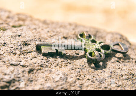 Schatz-Schlüssel verloren auf Felsen am Strand. Chance oder Mystery-Konzept. Stockfoto