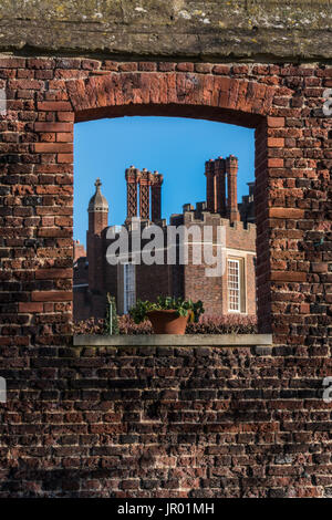 Detail der Schornsteine und Brüstung entlang des oberen Randes eine Tudor Gebäude Außenwand mit Fenster und Ornamente Stockfoto