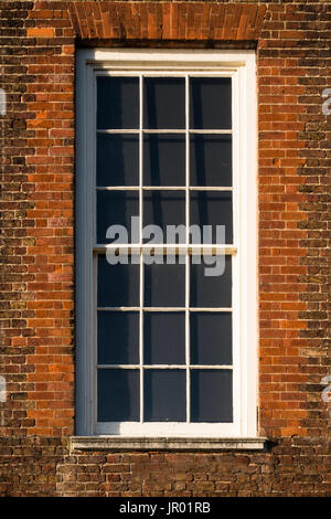 Nahaufnahme Detail des weißen Schiebefenster in rotem Backstein Außenwand des Tudor Periode Architekturgebäude Stockfoto