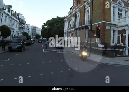 Das Bild wurde auf dem Bildschirm aufgenommen, das von der Metropolitan Police von Mopedfahrer-Dieben aufgenommen wurde, die in der Nähe des Londoner Kaufhauses Harrods einen Mann (Mitte, Hintergrund) mit Flüssigkeit übergossen hatten. Stockfoto