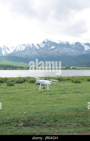 Mann-Controlling eine Drohne auf Gebirgshintergrund. Stockfoto