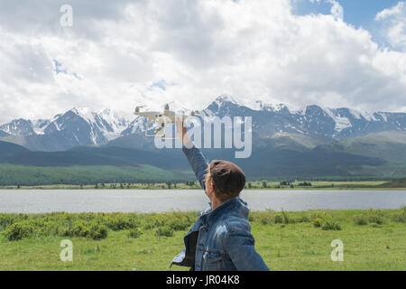 Mann-Controlling eine Drohne auf Gebirgshintergrund. Stockfoto