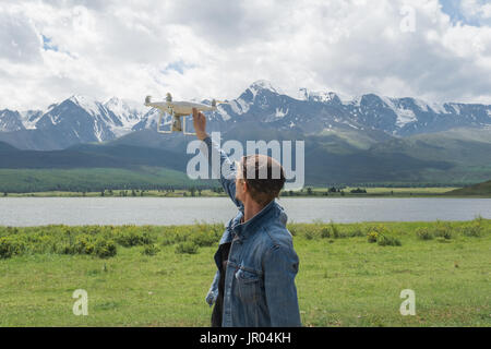 Mann-Controlling eine Drohne auf Gebirgshintergrund. Stockfoto