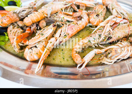 Gekochte Scampis Garnelen Garnelen in Weißwein-sauce mit Knoblauch und Petersilie, Nahaufnahme, isoliert Stockfoto