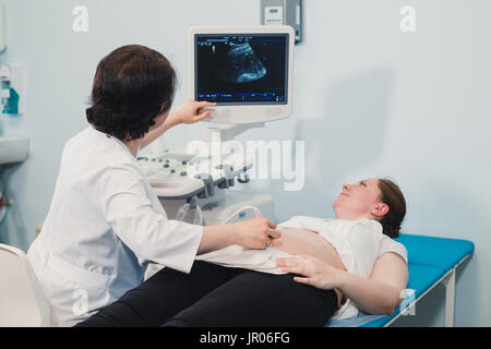 Schwangere Frau, die Ultraschallbehandlung im Krankenhaus Stockfoto