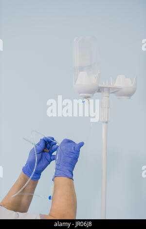 Des Arztes Hand und Infusion Tropf im Krankenhaus auf der Hintergrund jedoch unscharf Stockfoto