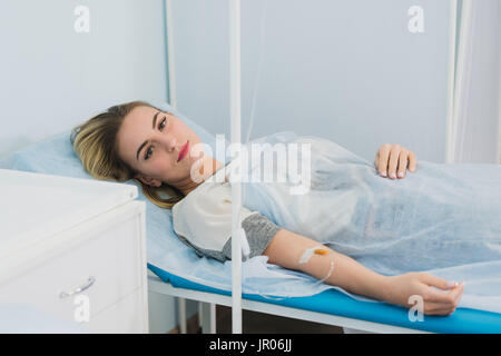 Frau liegend nach unten im Krankenhausbett und lächelnd. Stockfoto