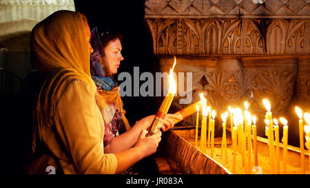 Gebete, die Kerzen in Heilig-Grab-Kirche Stockfoto