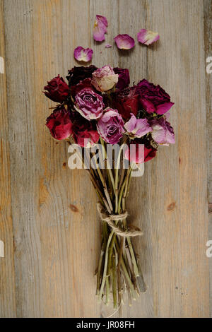 Bouquet von getrockneten Rosen auf einem hölzernen Hintergrund Stockfoto