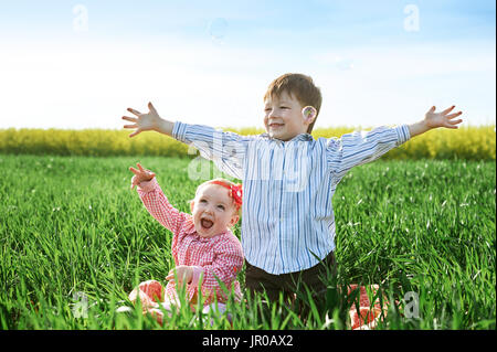 Kleine Kinder Jungen und Mädchen spielen auf dem grünen Rasen Stockfoto