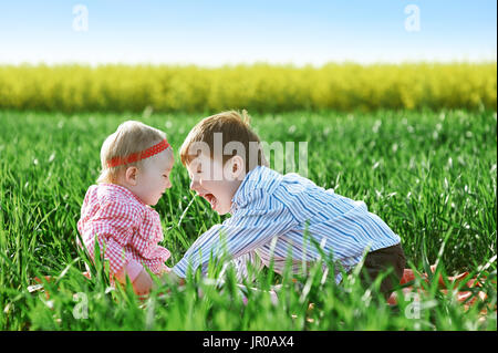 Kleine Kinder Jungen und Mädchen spielen auf dem grünen Rasen Stockfoto