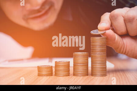 Spart Geld-Konzept und Hand setzen Geld Münze-Stack für Unternehmen wächst Stockfoto