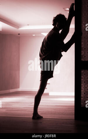 Männliche Yogalehrer tun teilt Bein Strecken Flexibilität Gymnastik und Yoga Asanapraxis im Fitness-Studio Stockfoto