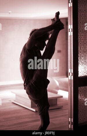 Männliche Yogalehrer tun teilt Bein Strecken Flexibilität Gymnastik und Yoga Asanapraxis im Fitness-Studio Stockfoto