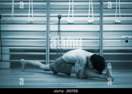 Männliche Yogalehrer tun teilt Gymnastik und Yoga Asanapraxis im Fitness-Studio Fitness Pilates-Studio. Stockfoto